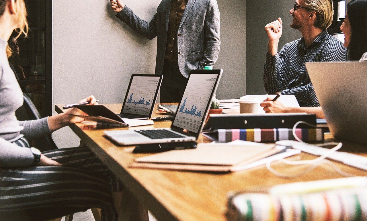 A team working together at laptops around a meeting table